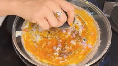 Crispy ghee karam onion egg dosa topped with onions and podi